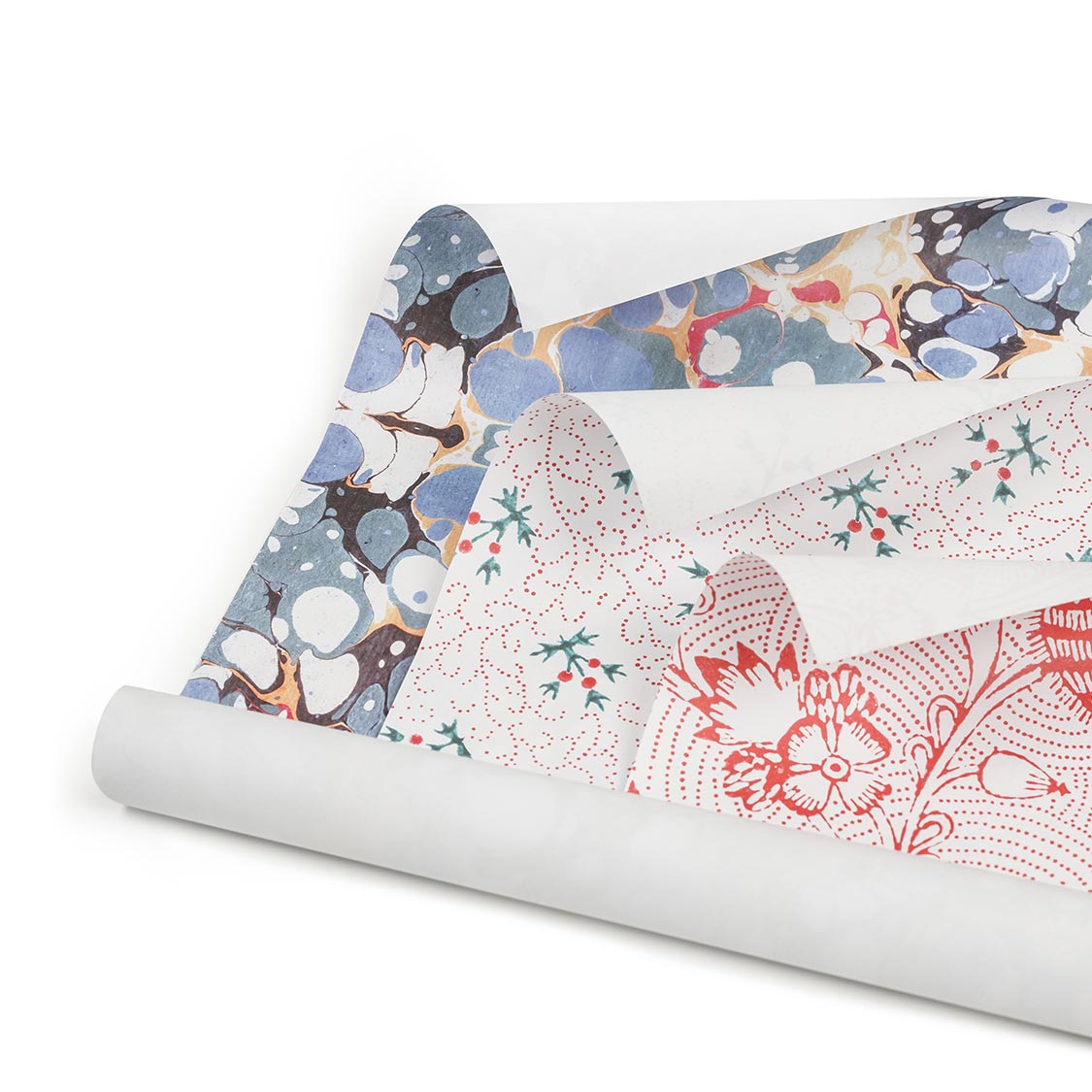 Eingerolltes Geschenkpapier, drei Motive übereinander.