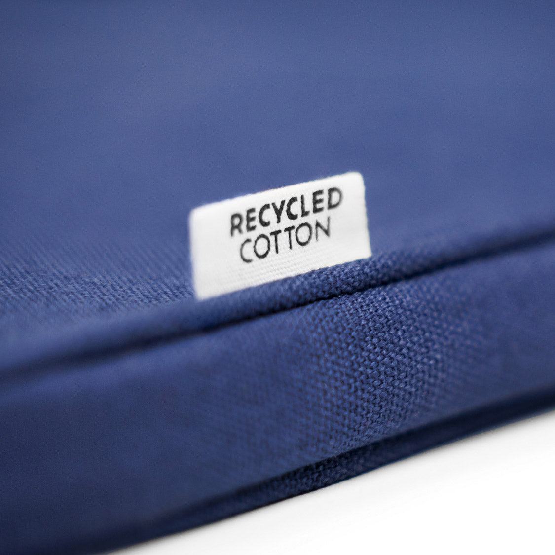 Detailaufnahme eines Labels der Laptophülle, auf dem Label steht "Recycled Cotton"