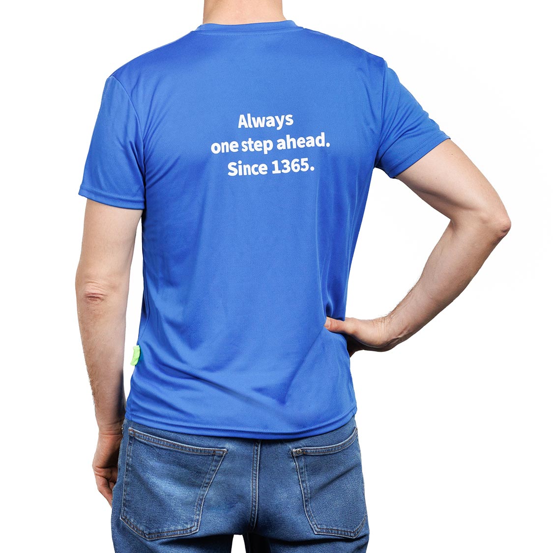 Rückansicht eines blauen Sport-T‑Shirts mit weißem Text: „Always one step ahead. Since 1365.“