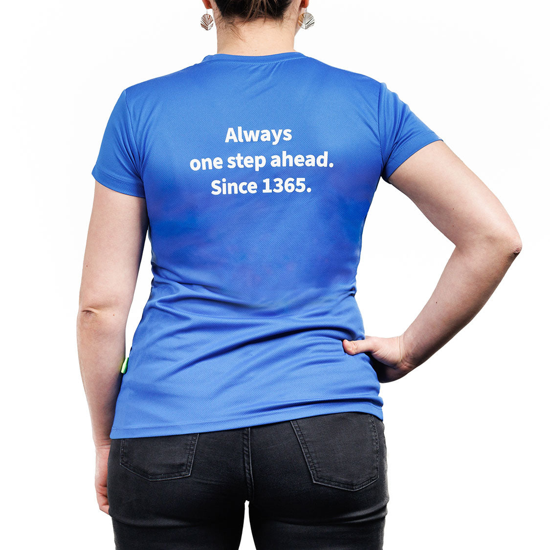Rückansicht eines blauen Sport-T‑Shirts mit weißem Aufdruck: „Always one step ahead. Since 1365.“