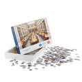 Abbildung eines Puzzles mit Motiv des Großen Lesaals in der Hauptbibliothek der Universität Wien. Das Puzzle ist geöffnet und neben dem Puzzle liegen diverse farbige Puzzlestücke.