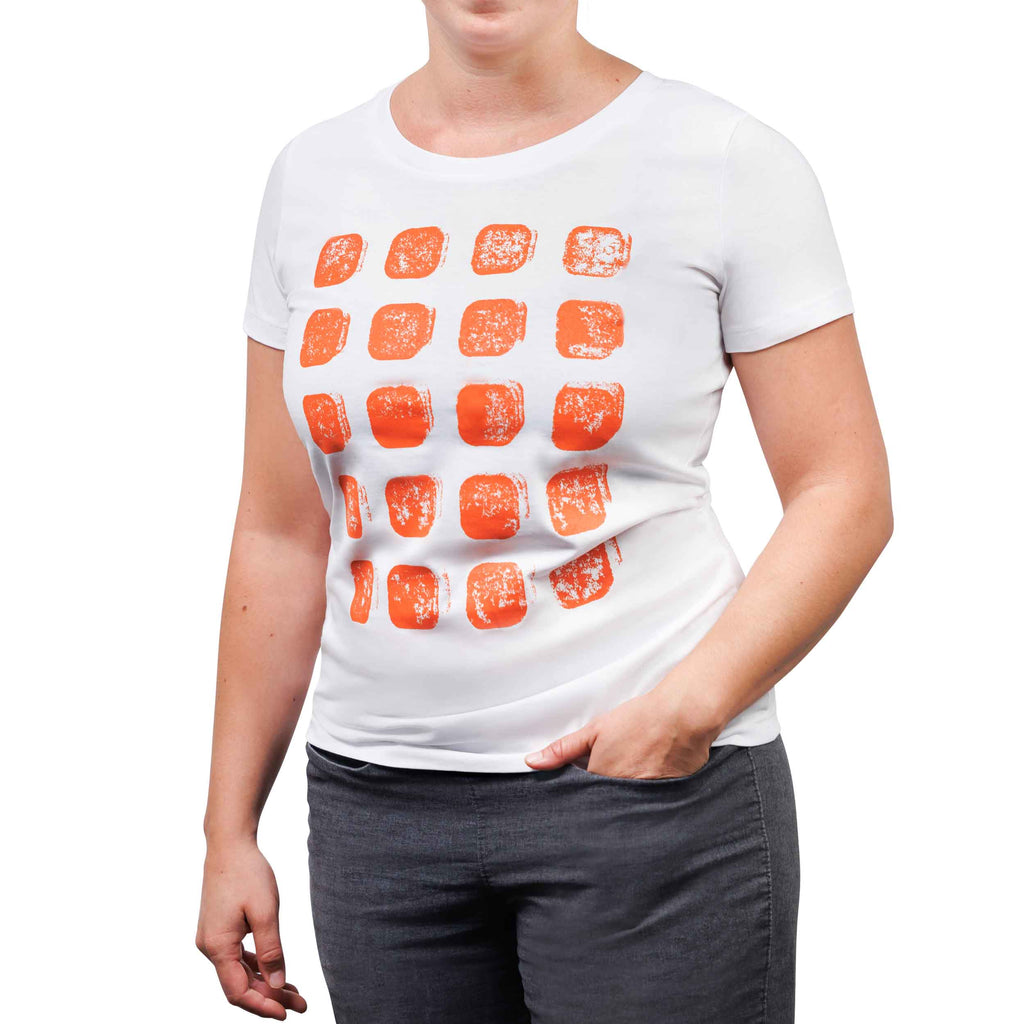 Weibliches Fotomodel mit weißem T-Shirt, aufgedruck zwanzig orangene Kacheln in fünf Reihen.