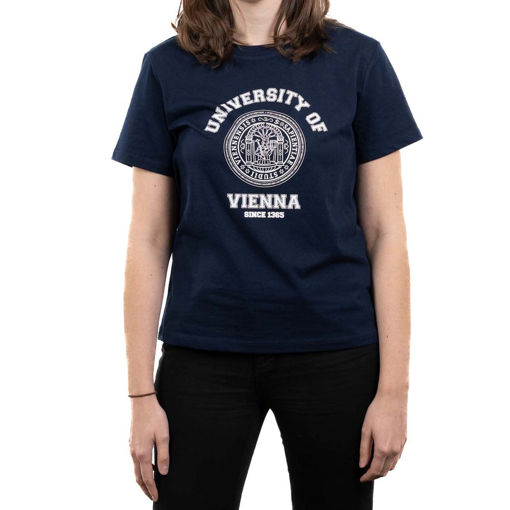 Frontansicht einer weiblichen Person im dunkelblauen T‑Shirt. Auf der Brust ein großer weißer Collegedruck mit Siegel: „UNIVERSITÄT WIEN“ und darunter „SEIT 1365“.