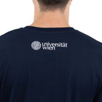Rückansicht eines dunkelblauen T‑Shirts. Am oberen Rücken ist in Weiß das Logo „Universität Wien“ mit Siegel aufgedruckt.